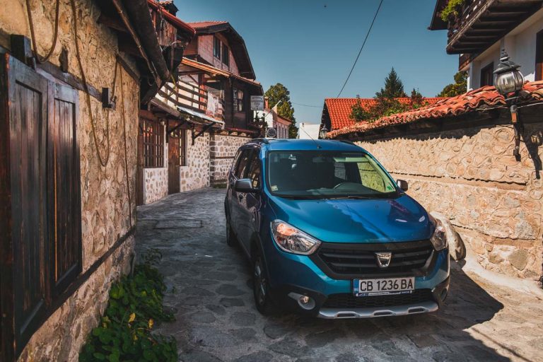 This photo shows our private airport transfer car outside the guesthouse we stayed at in Bansko Old Town. Hoppa airport transfers. How to get from Sofia to Bansko Bulgaria.