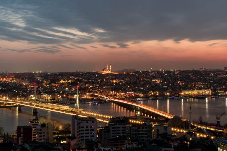 This photo was taken from the top of Galata Tower at sunset. The sky is pink and blue. In the distance, Suleymaniye mosque is lit and soars above the other buildings below. It's a panoramic view just as the city lights up. This is the photo we chose to be the featured image for our article: The best 5 days in Istanbul Itinerary + Guide