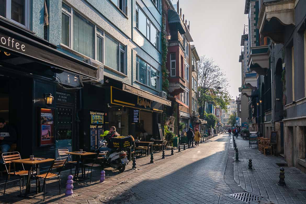 A paved street in Kadikoy. It is lined with cafes with tables and chairs.