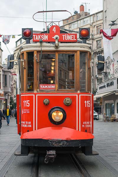 The old-fashioned red tram on Istiklal. On top of the tram there is a sign with number 4 and the route taksim - tunel.