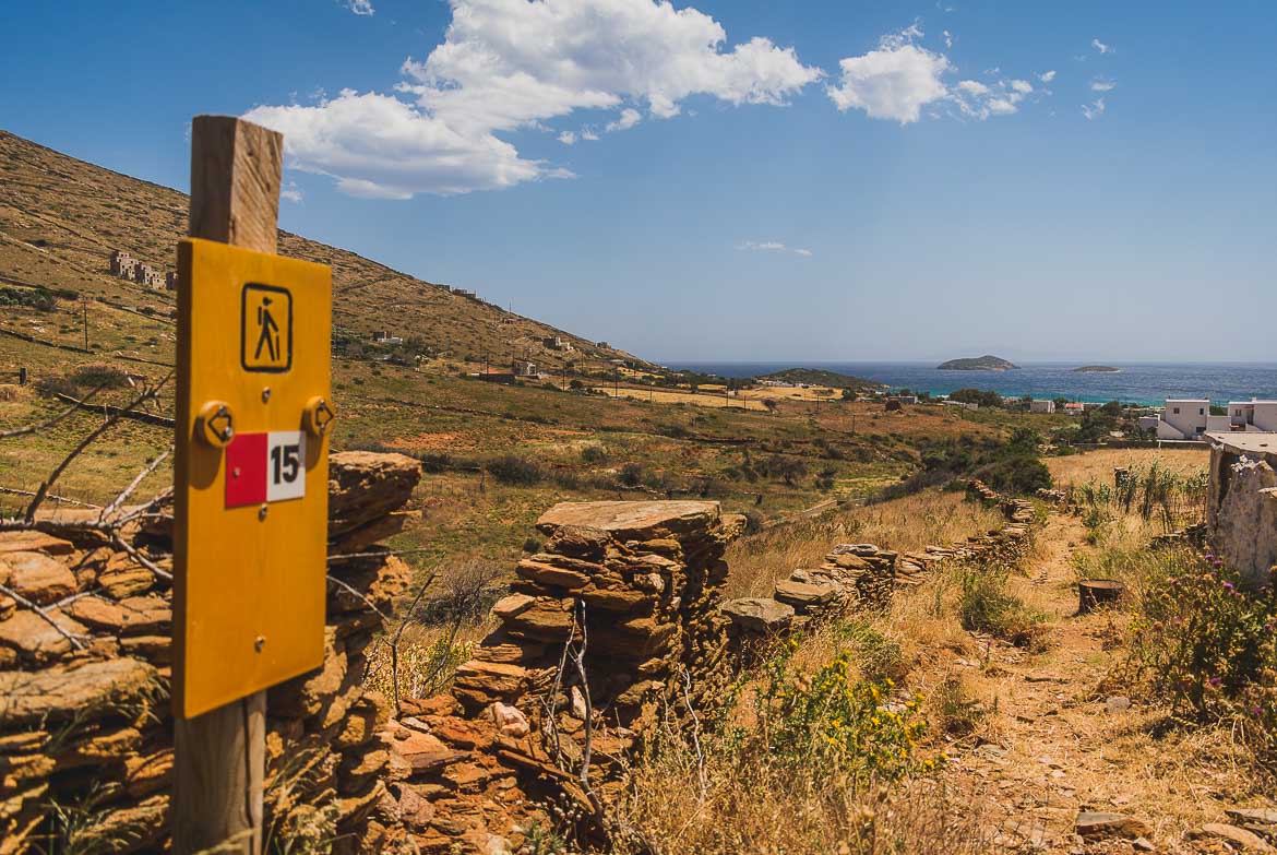 This picture shows a signpost of route 15 with the sea in the background. Andros hiking means walking along paths of unique natural beauty.