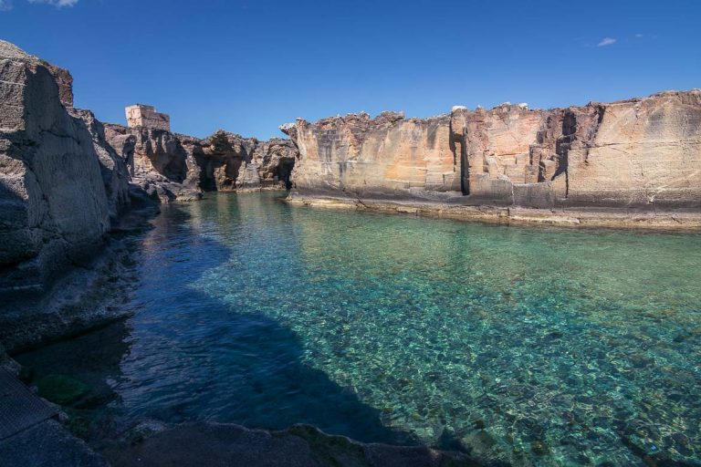 This is a photo of Marina Serra, a shallow natural pool with crystal clear waters surrounded by cliffs.