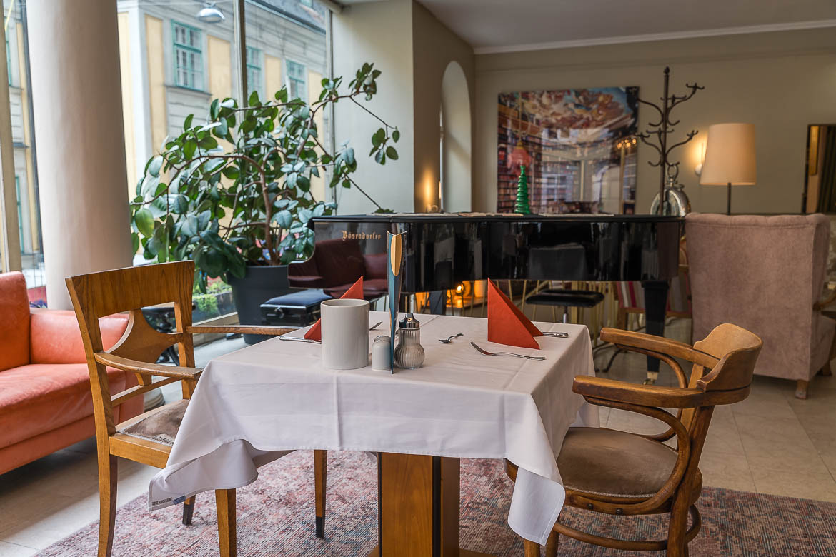 A breakfast table with a piano in the background at Hotel Beethoven Wien, one of the best places to stay in Vienna.