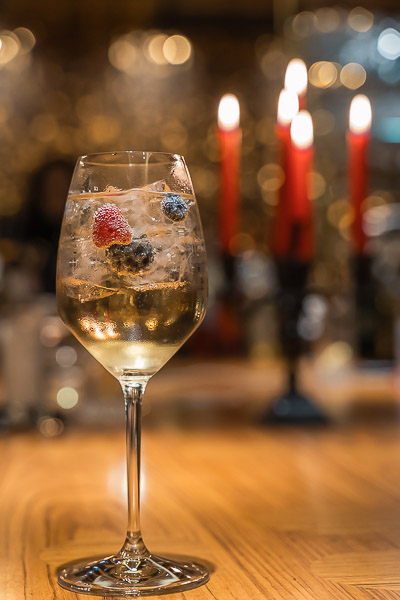 A wine-based cocktail with fruit, served in a wine glass.