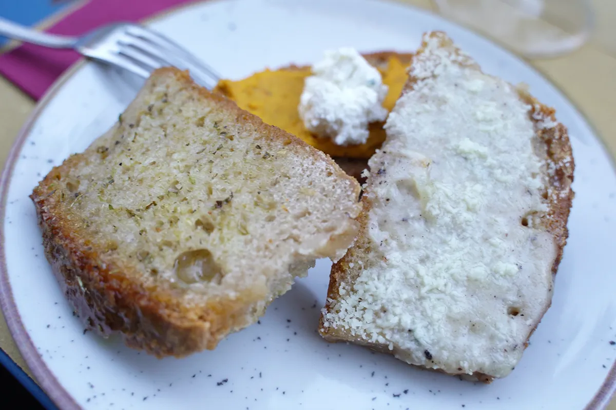 A close-up of three pieces of bread with various toppings.