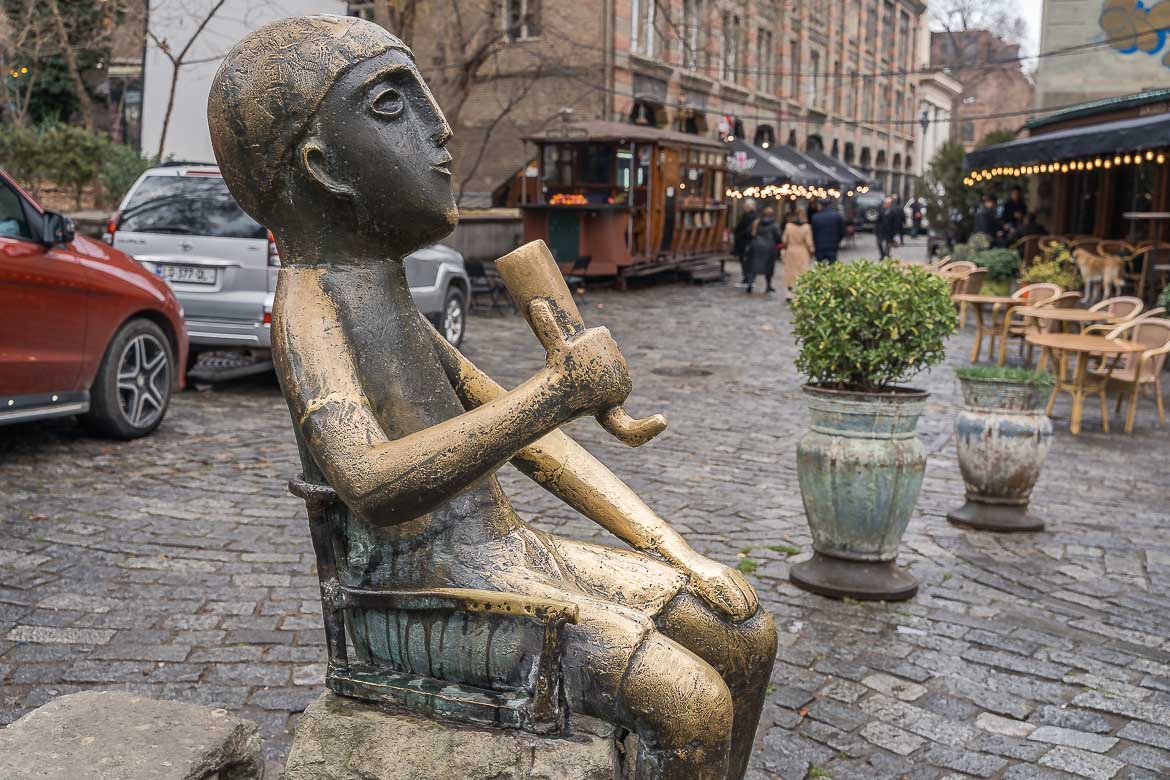 A bronze statue of the Georgian Tamada. The Statue is on a pedestrianised street in Tbilisi Old Town.