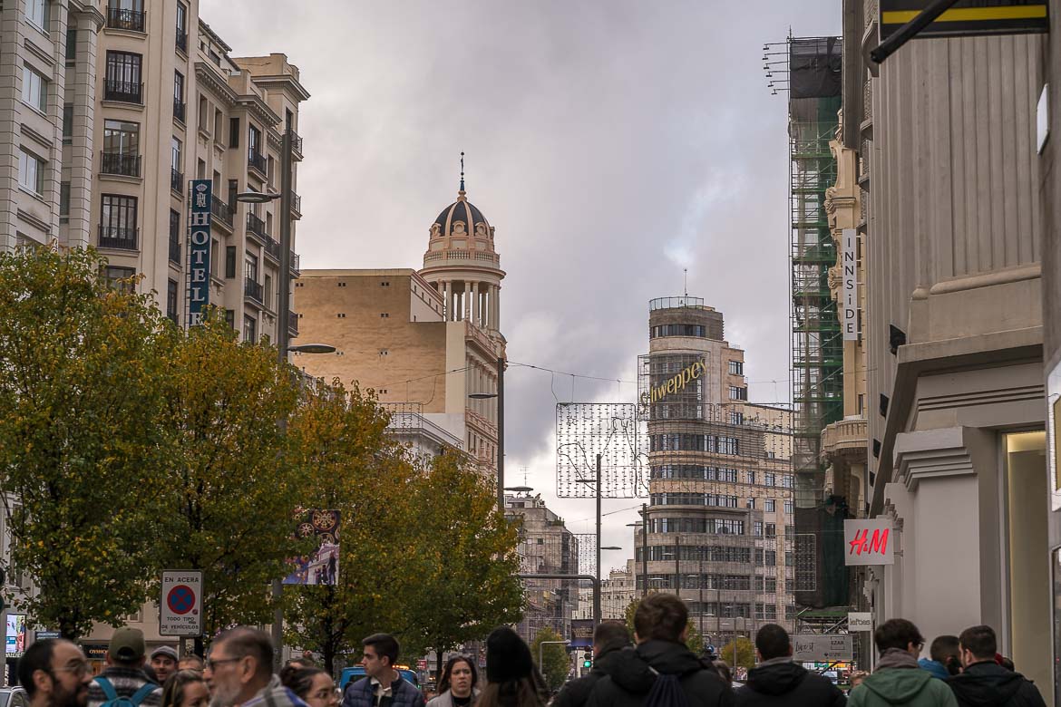 This image shows Gran Via with people passing by.