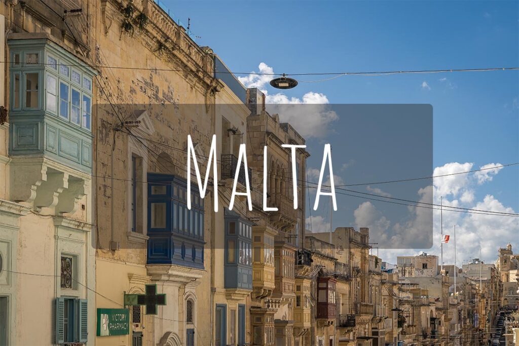 Traditional buildings with colourful wooden balconies in Valletta. There's overlay text that reads Malta.