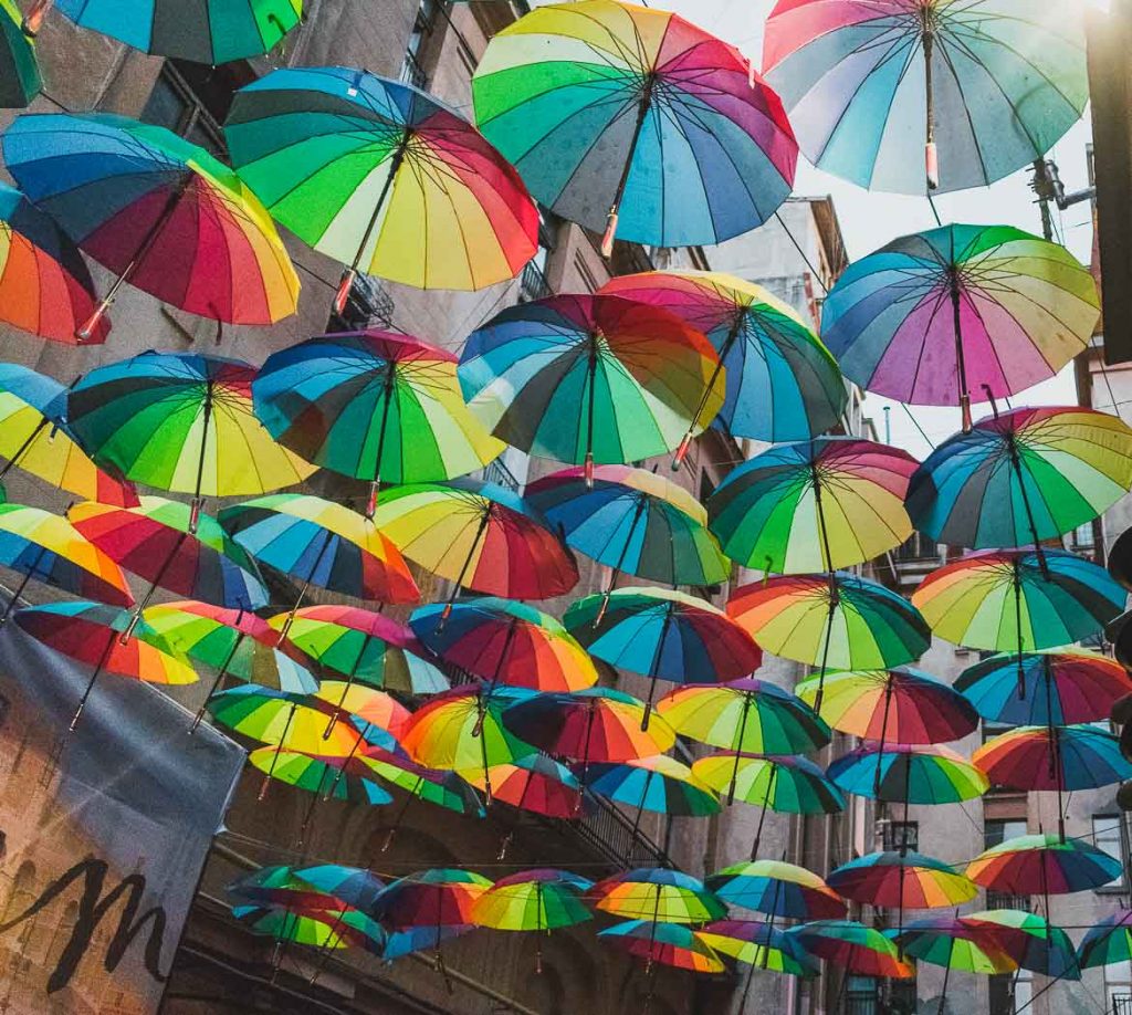 This photo shows the famous street with hanging colourful umbrellas, one of the top things to do in Bucharest, Romania. It is located in Pasajul Victoria, in the city centre.