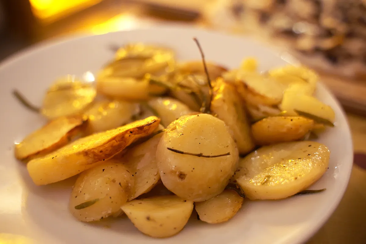 A close-up of oven-baked potatoes with rosemary.