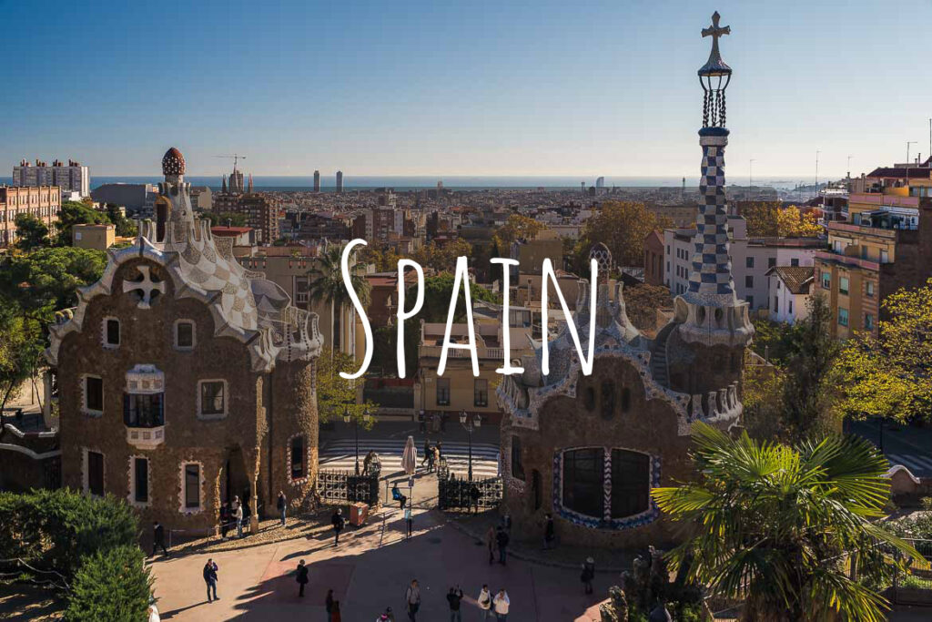 This is a panoramic view of Park Guell in Barcelona, Spain. There's overlay text that reads Spain.