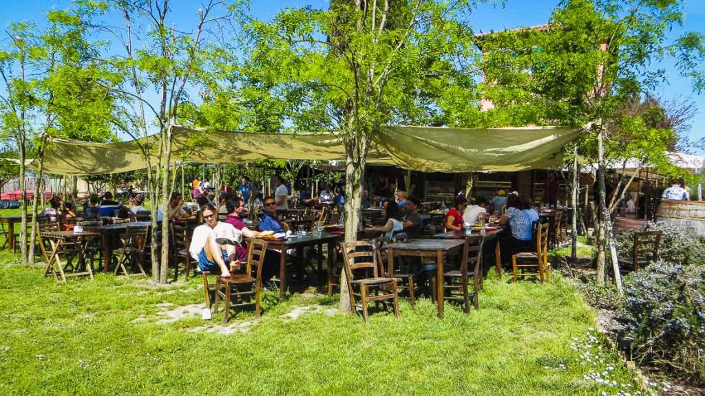 This is a photo of the garden area at Taverna Tipica Veneziana in Torcello, Veneto, Italy. Venice Islands, the perfect Venice day trip.