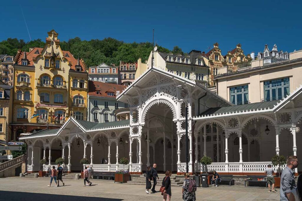 The white wooden Market Colonnade. People are walking on the pedestrianised street in front of the colonnade.