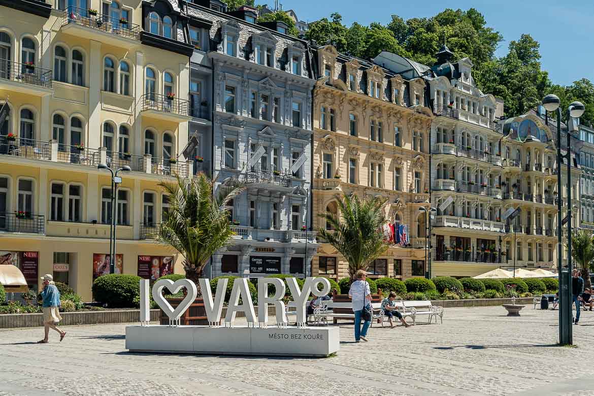 A big sign reading "I love Karlovy Vary" in the middle of a pedestrianised street at the heart of the town. Love at the sign is shown with a heart shape. 