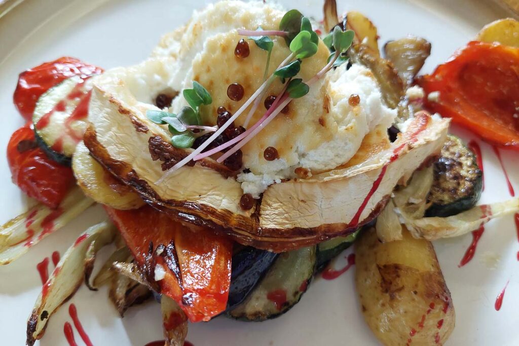 This image shows a vegetarian dish with grilled cheese and vegetables.