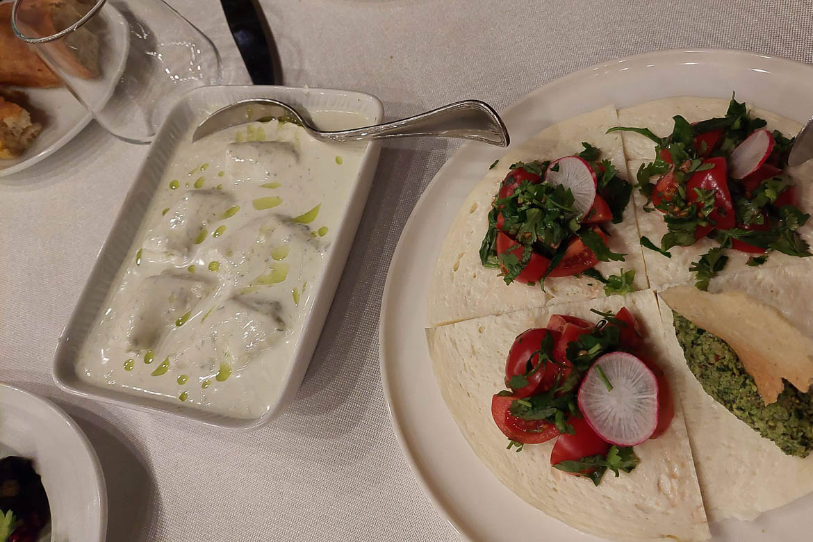 A dish of Gebzhalia and a dish with appetisers, such as tomatoes and Pkhali. 