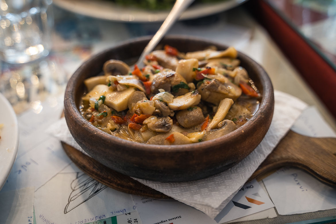 A close up of a clay pot filled with mushrooms, a staple ingredient of vegetarian Georgian food. 