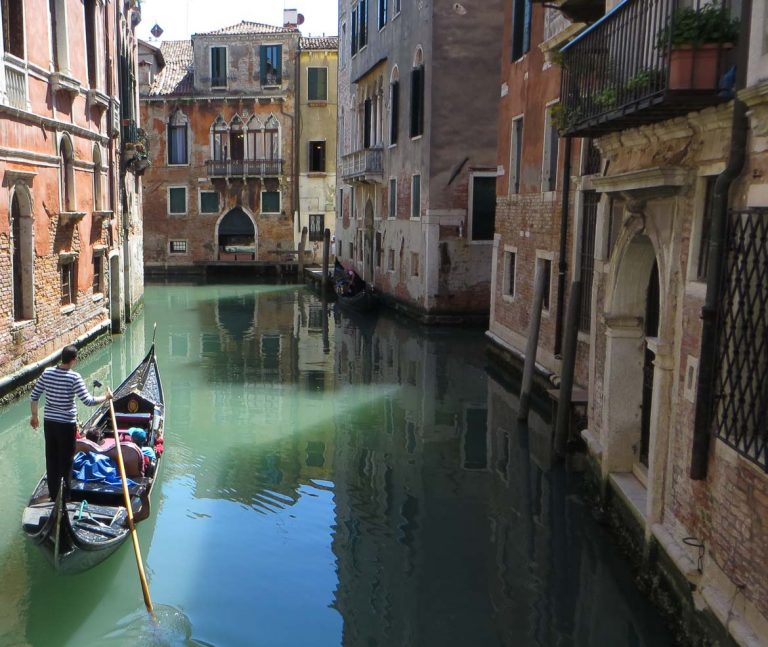 This photo shows a gondola in a quiet canal in Venice.