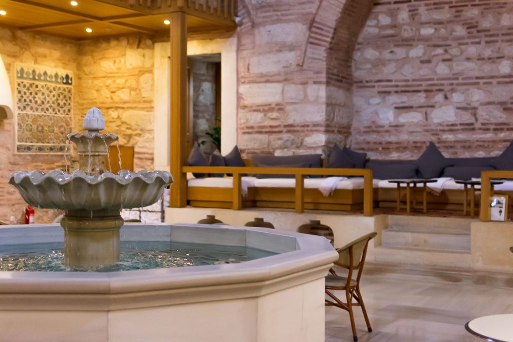 What Happens in a Turkish Bath? A First-Timer’s Guide This image shows the white marble fountain dominating the lounge area at Kilic Ali Pasa Hamami in Istanbul. It is the featured image of our article: What happens in a Turkish bath? Top tips for first-timers.