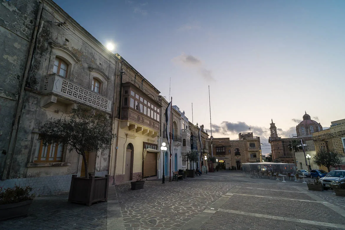 Nadur's main square on blue hour. There are a few bar-restaurants with outdoor seating on the square.