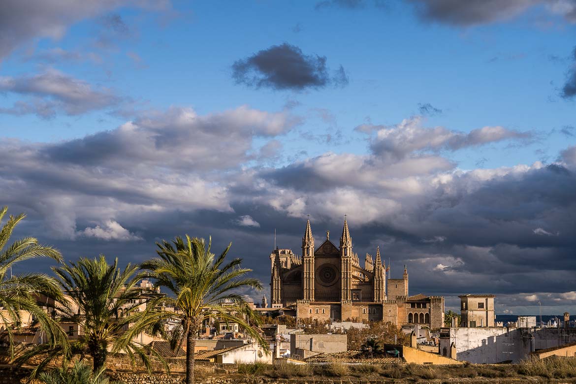 This image shows the Cathedral of Palma de Mallorca in winter, under a dramatic cloudy sky.